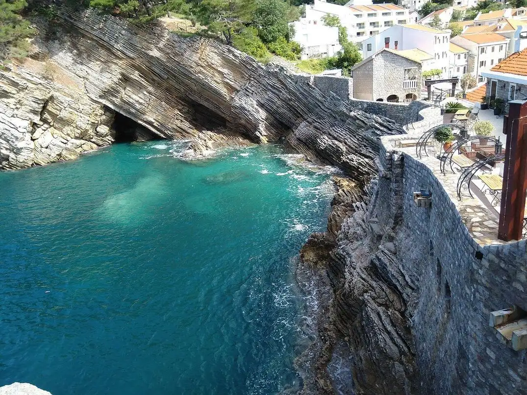 Clear turquoise water in a rocky cove below cliffs on the coast path south of Petrovac