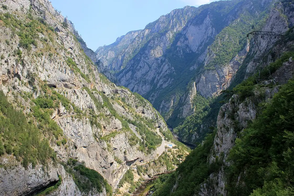Steep forested cliffs rising from the green Piva River canyon in northern Montenegro
