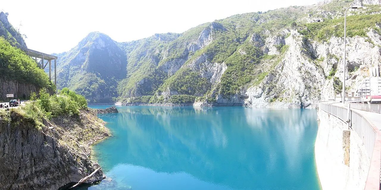 The Mratinje Dam wall at the head of Piva Lake with turquoise water in the foreground
