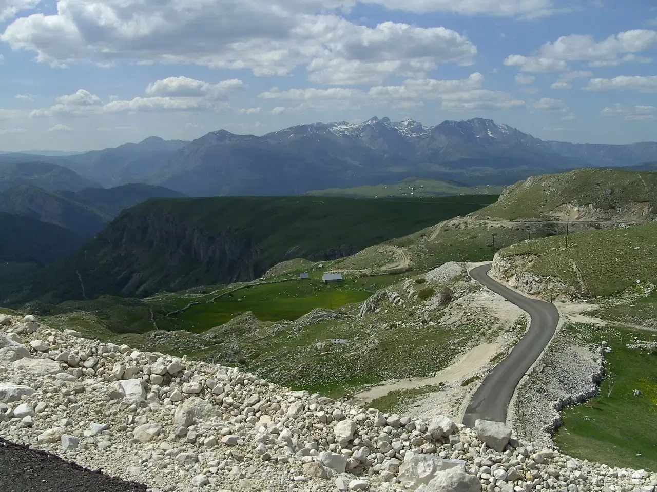 Newly paved mountain road through Durmitor National Park with the Maglić range behind