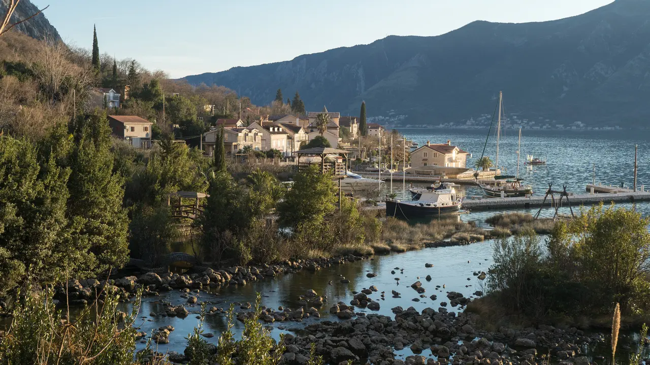 The Ljuta river mouth flowing into the Bay of Kotor past village houses