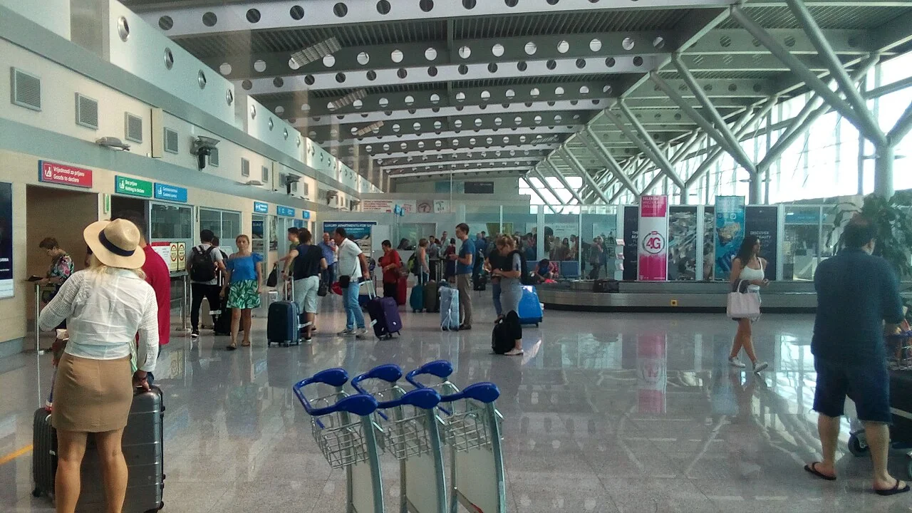 Travellers with luggage in the arrivals hall at Podgorica Airport, Montenegro