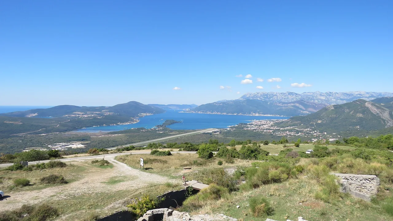 Tivat Bay and the runway of Tivat Airport on the shore, seen from the hills above