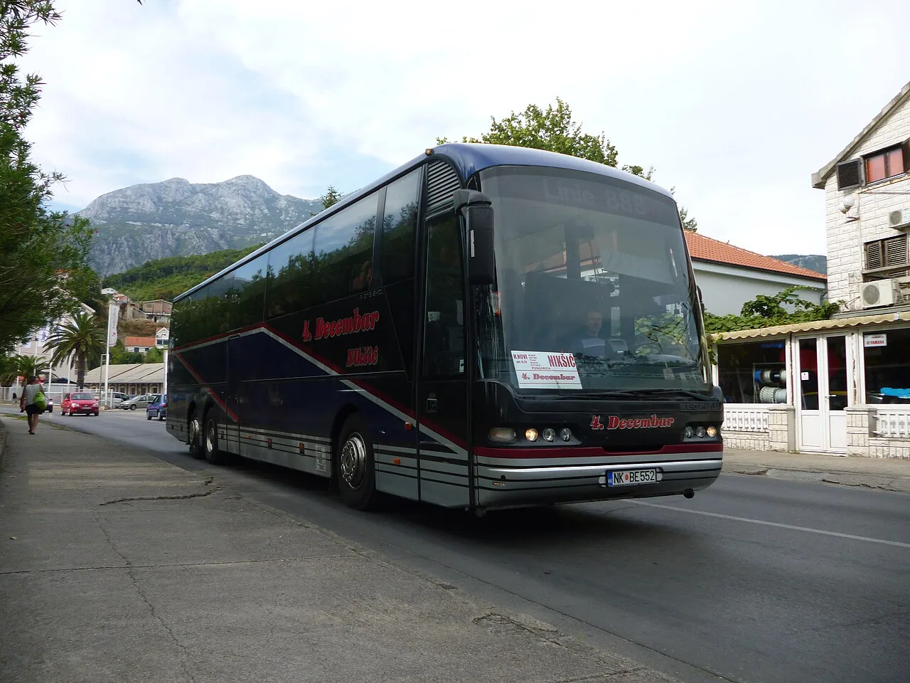A Montenegrin intercity coach operated by 4 Decembar parked at a station