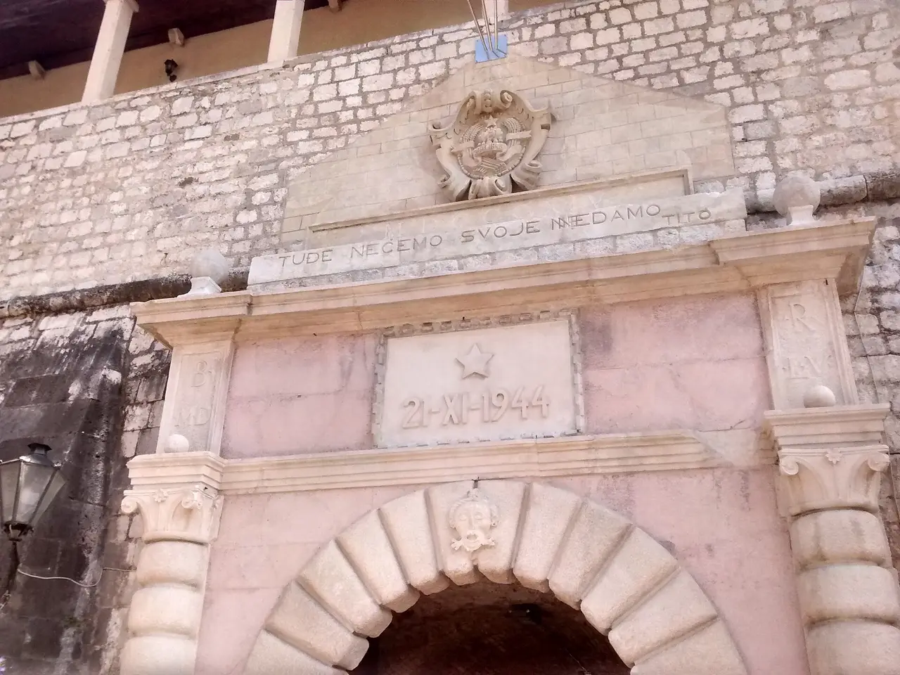 The Sea Gate, the main stone entrance into Kotor old town, with the 1944 plaque above the arch