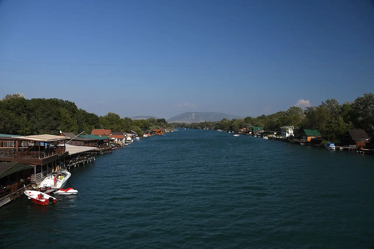 The emerald Bojana river at Ada Bojana lined with wooden stilt fish restaurants and small boats