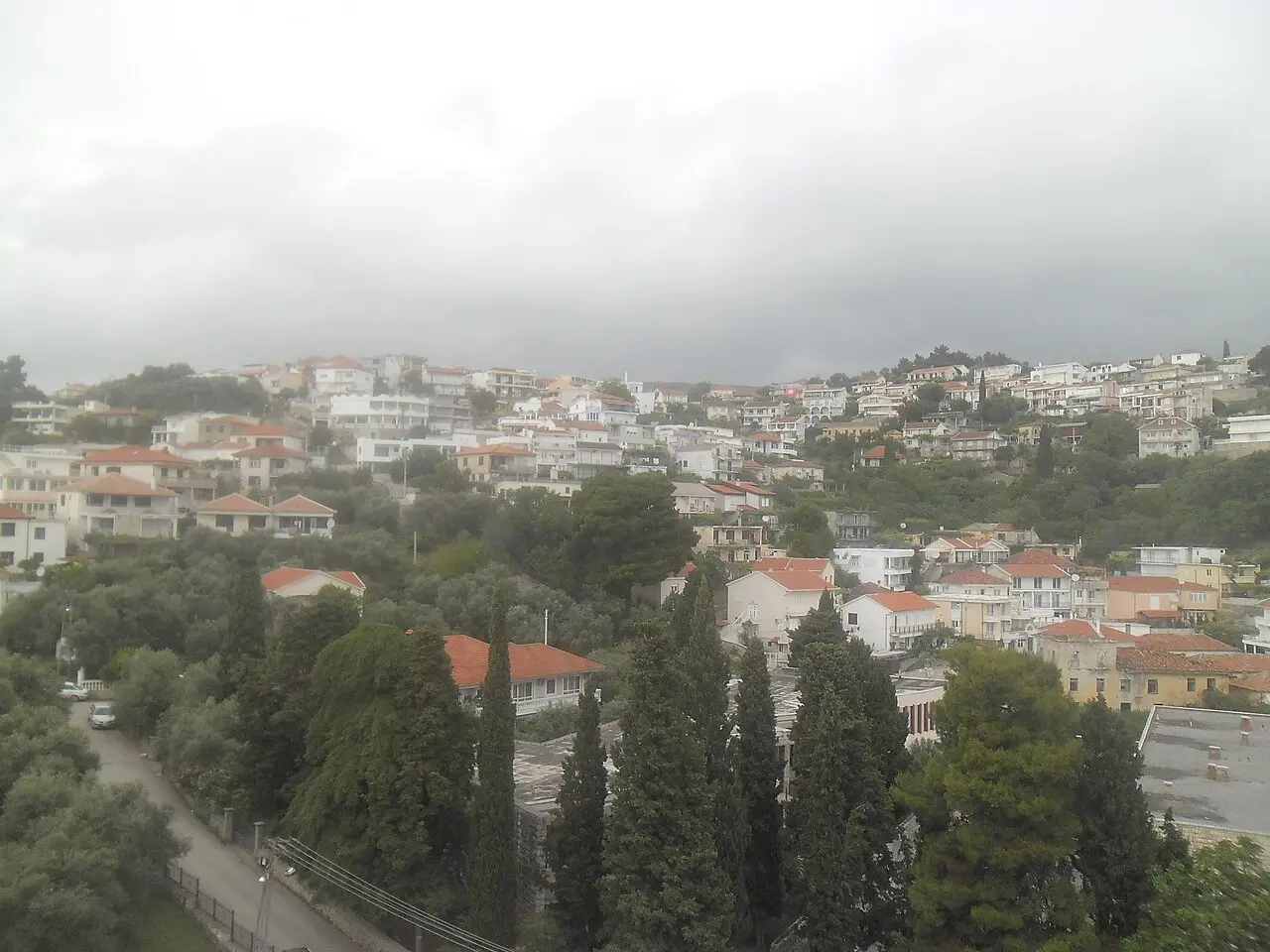 Ulcinj town rising up the hill behind Mala Plaza, with a mosque minaret among the houses