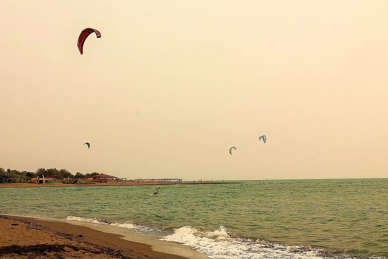 Kitesurfers riding off the long sandy Velika Plaza near Ulcinj with kites overhead