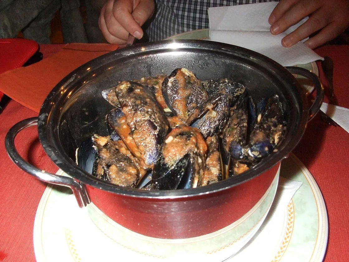 A pot of mušule na buzaru, mussels in a red garlic-and-tomato buzara sauce, served in a konoba