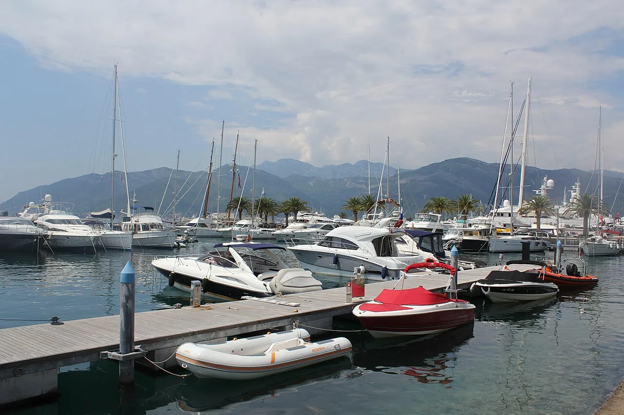 Yachts moored along the Porto Montenegro quay with marina buildings behind