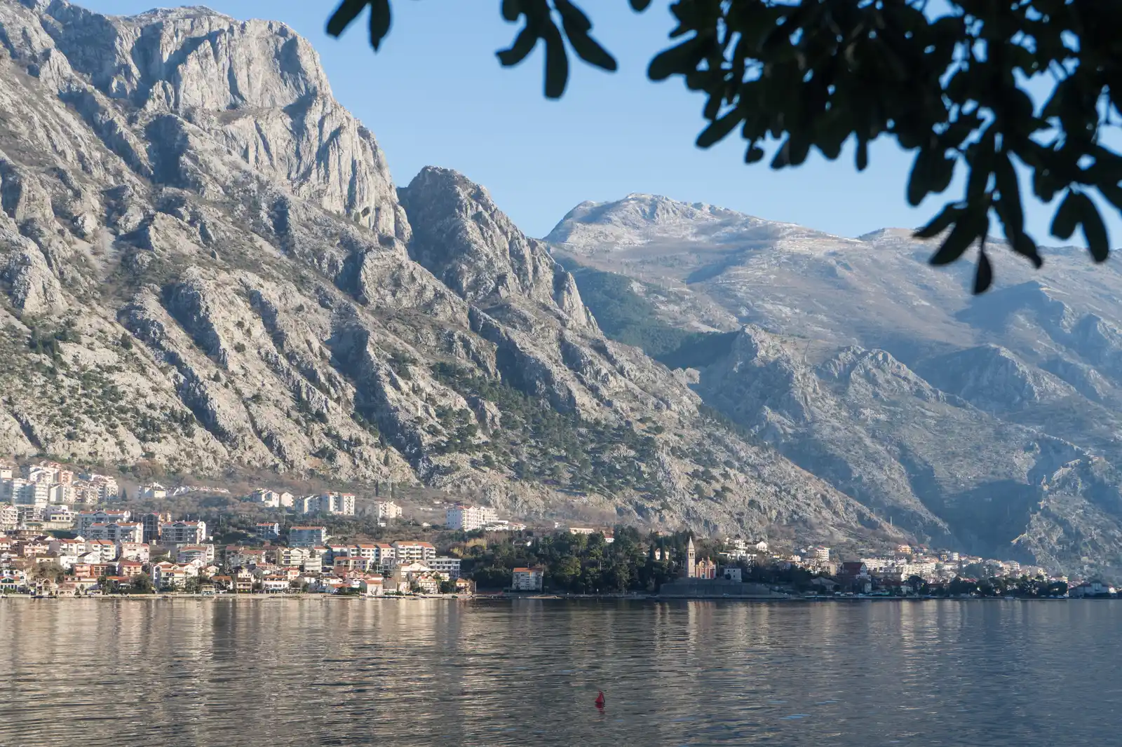 The waterfront settlement of Dobrota stretching along the Bay of Kotor below steep grey mountains