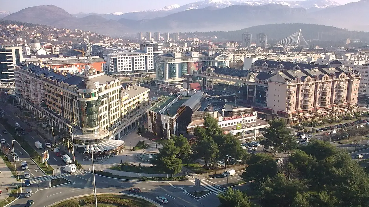Aerial view over central Podgorica with the Nova Varoš roundabout, modern buildings and mountains behind