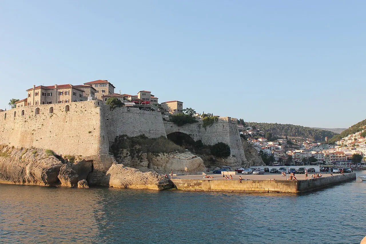 Stone ramparts and rooftops inside Ulcinj Old Town, with the Adriatic visible beyond the walls